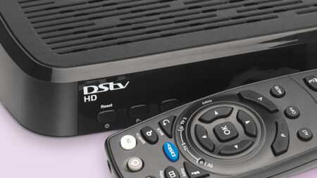 DStv decoder and remote beside a television